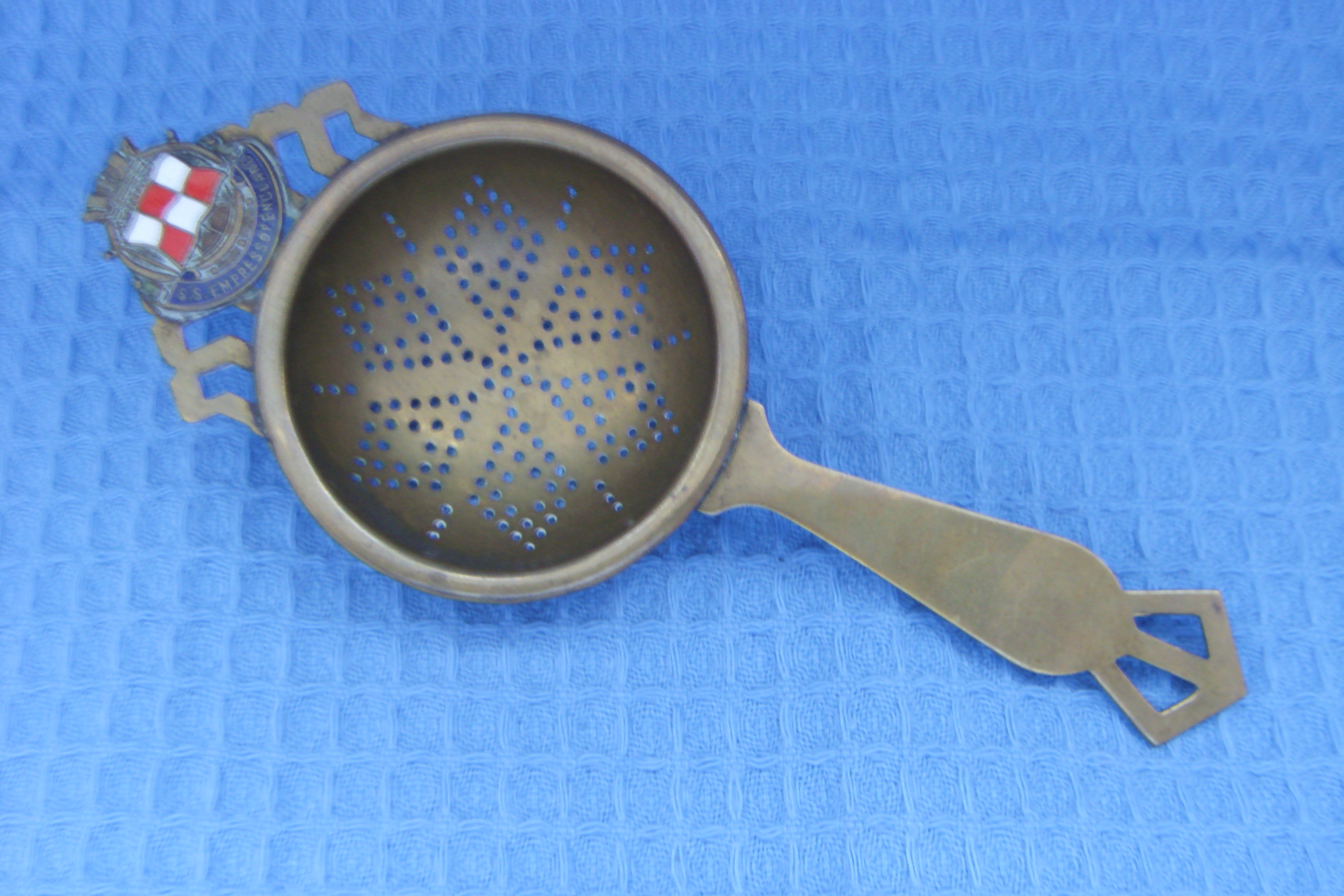 SOUVENIR TEA STRAINER FROM THE VESSEL EMPRESS OF ENGLAND OF THE CANADIAN PACIFIC STEAMSHIP COMPANY